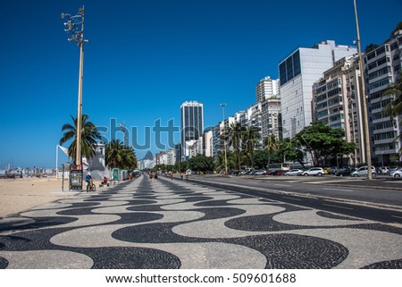 Worldwide famous Copacabana promenade with palm trees, residential buildings, hotels and black and white mosaic of Portuguese pavement in Rio de Janeiro, Brazil