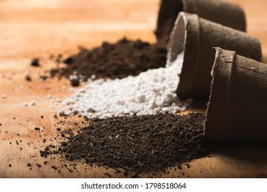 Worm Humus Coming Out Of A Peat Pot With Perlite And Peat Moss As Substrate Materials On A Raw Wooden Surface. Organic And Home Farming Concept.