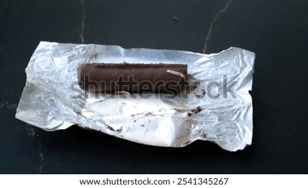 Worms crawls on chocolate candy. Crawling larvae and eggs laid on food. Not fresh spoiled product. A disgusting sight. Sickening and disgusting. Violation of storage conditions in a grocery store.