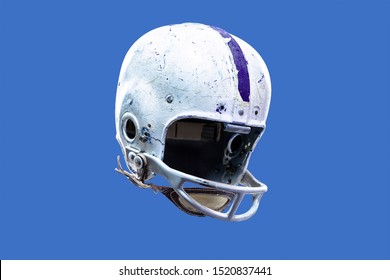 A worn and aged vintage old style American football helmet. Authentic and game-worn 1950s style football face mask and helmet