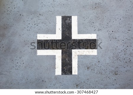 Worn black and white german cross from world war II on an old tank