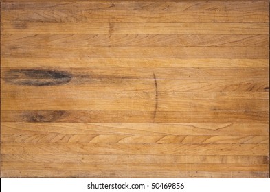 A Worn Butcher Block Cutting Board Sits As A Background