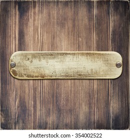 Worn Metal Label Plate Nailed To Wooden Background