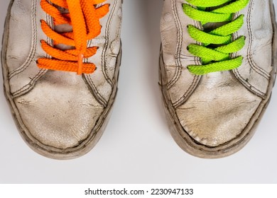 worn old torn white sneakers with colored laces on a white background - Powered by Shutterstock