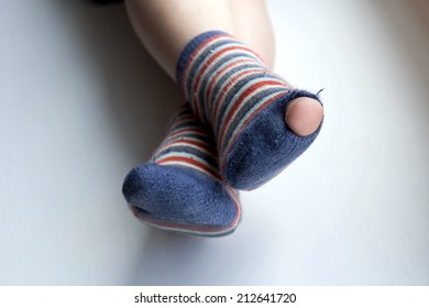 Worn Out Socks. Worn Socks With A Hole And A Finger Sticking Out Of Them