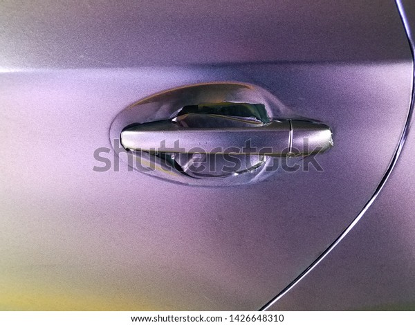 worn purple\
wrap on automobile with door\
handle