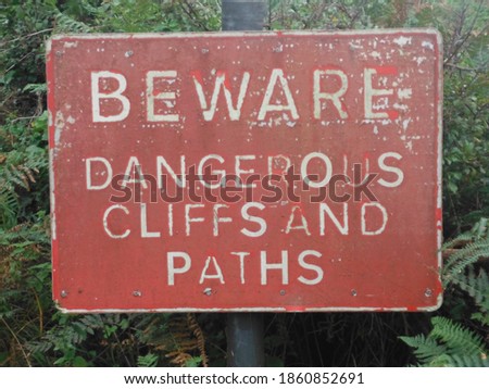 worn red beware dangerous cliffs and paths sign