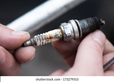 A Worn Spark Plug In Male Hand