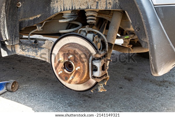 Worn used car brake disk close up.\
Repairing brakes on a car. Changing wheels and\
brakes