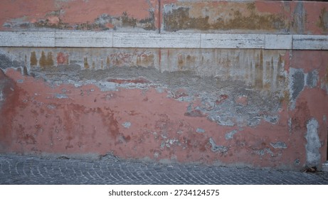 Worn weathered plaster wall texture with peeling paint, exposed masonry band and aged stucco, sharp wall detail street; background backdrop copyspace template.