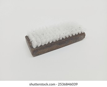 A worn wooden brush with white bristles on a plain white background, showcasing a vintage, minimalistic design. - Powered by Shutterstock