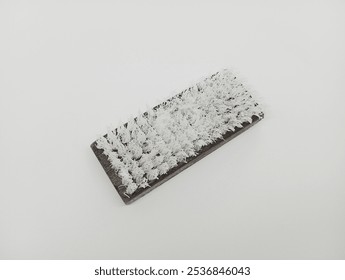 A worn wooden brush with white bristles on a plain white background, showcasing a vintage, minimalistic design. - Powered by Shutterstock