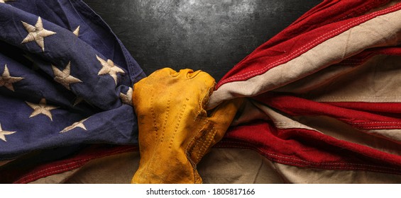 Worn Work Glove Holding Old US American Flag. Made In USA, American Workforce, Blue Collar Worker, Or Labor Day Concept.