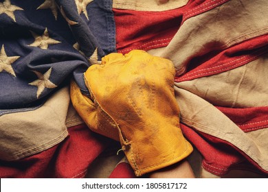 Worn Work Glove Holding Old US American Flag. Made In USA, American Workforce, Blue Collar Worker, Or Labor Day Concept.