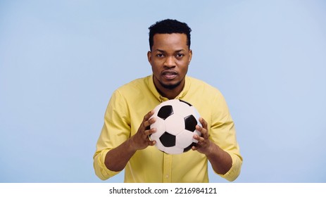 Worried African American Man Holding Football Isolated On Blue