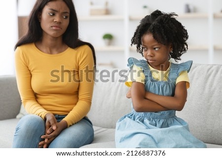 Worried Black Mother Looking At Offended Little Daughter After Argue At Home, Young African American Mom And Preteen Female Child Suffering Misunderstanding And Communication Problems, Closeup