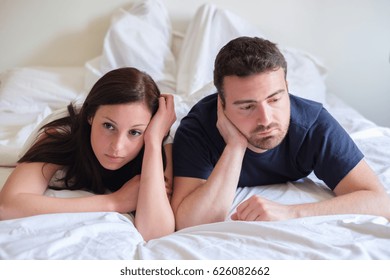 Worried and bored lovers couple after a fight lying in the bed