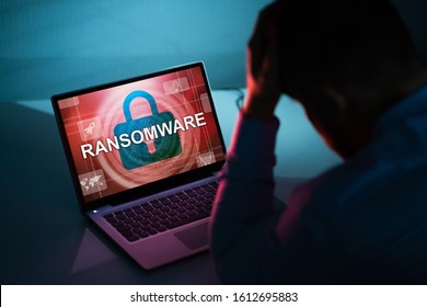 Worried Businessman Looking At Laptop With Ransomware Word On The Screen At The Workplace - Shutterstock ID 1612695883