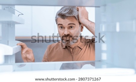 Worried Caucasian Man Checking Empty Refrigerator At Home, Weight Loss Concept