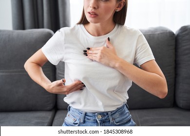 Worried caucasian woman carefully looking and checking breast by herself that she concern about breast cancer. Breast cancer concept - Shutterstock ID 1845308968