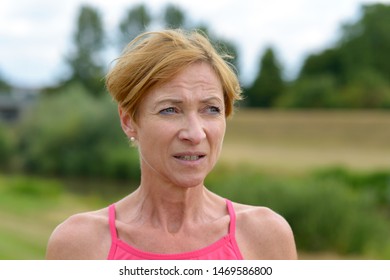 Worried Concerned Woman Frowning As She Looks To The Side With A Thoughtful Watchful Expression In A Close Up Portrait Outdoors