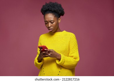 Worried confused irritated african american woman holding mobile phone, reading bad news in message annoyed by spam