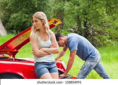 Worried Couple Waiting For Assistance After Breaking Down With Their Car