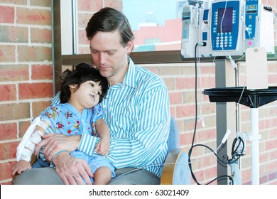 Worried Father Holding Sick Child In Hospital