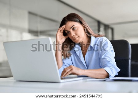 Worried fatigued mature business woman having headache at work. Tired upset busy 40s middle aged businesswoman feeling stress having problem at workplace looking at laptop computer in office.