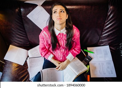 Worried female student stressing about exams and school. Studying at home, online class learning difficulties.College exam frustration. School-related anxiety. Notes and test books