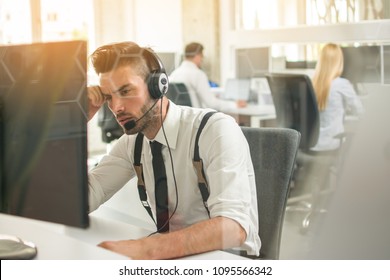 Worried Or Frustrated Business Man With Headset Working On Computer In Office