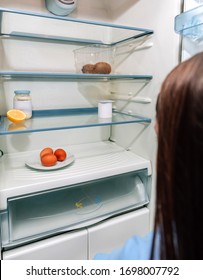 Worried Girl Looking At The Almost Empty Fridge Due To A Crisis