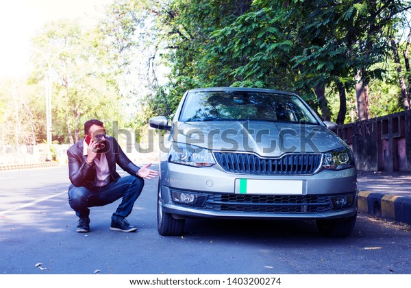 worried Indian Businessman with vehicle/car\
breakdown, talking on\
phone