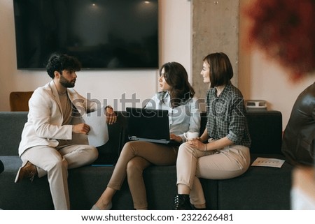 Worried male employee thinks he made a big mistake at the project, even know that he did not. His female colleagues are smiling at him