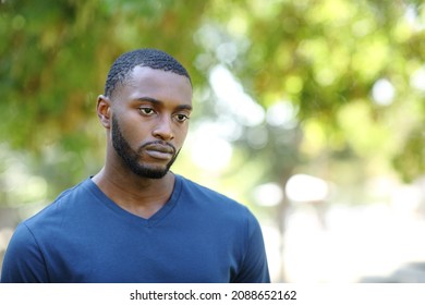 Worried Man With Black Skin Distracted Looking Away Walking In A Park