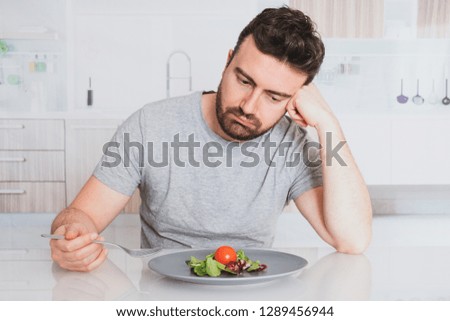 Worried man hungry and starved with salad
