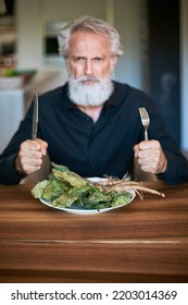 Worried Man Looking At Dead Salad On His Plate In His Kitchen. Surprised. Sad. Emotions. 