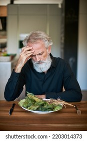 Worried Man Looking At Dead Salad On His Plate In His Kitchen. Surprised. Sad. Emotions. 