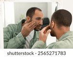 Worried man looking at mirror at home