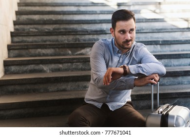 Worried man waiting at the train station with luggage