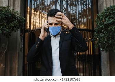 worried man wearing face mask against contagious coronavirus and talking by phone outside in street - Powered by Shutterstock