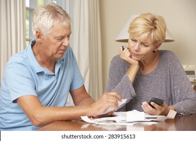 Worried Mature Couple Checking Finances And Going Through Bills Together