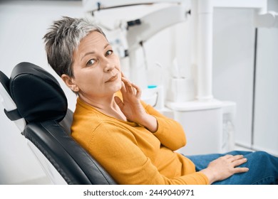 Worried mature woman sitting in dental examination chair - Powered by Shutterstock