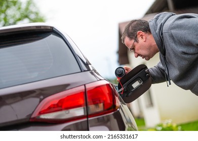 Worried Middle-aged Man Looking At Open Car Fuel Tank, Concept Of Rising Fuel Prices