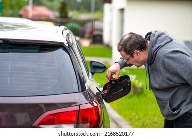 Worried Middle-aged Man Looking At Open Car Fuel Tank, Concept Of Rising Fuel Prices