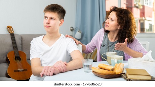 Worried Mother Having Serious Conversation With Teen Boy At Home