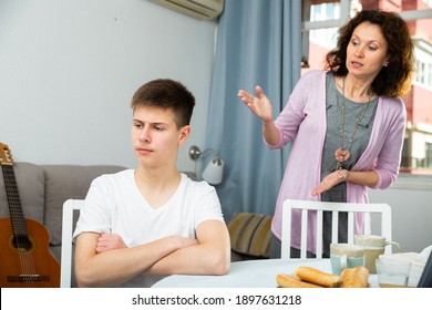 Worried Mother Having Serious Conversation With Teen Boy At Home