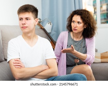 Worried Mother Having Serious Conversation With Teen Boy At Home