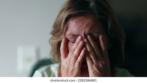 Worried older woman portrait feeling anxiety. Senior woman in 60s covering face - Powered by Shutterstock