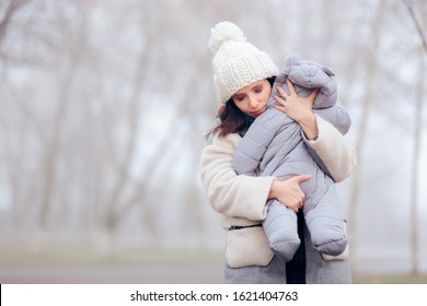 Worried Overprotective Mother Holding Baby In Cold Weather. Protective Mom And Daughter In Wintertime Season
